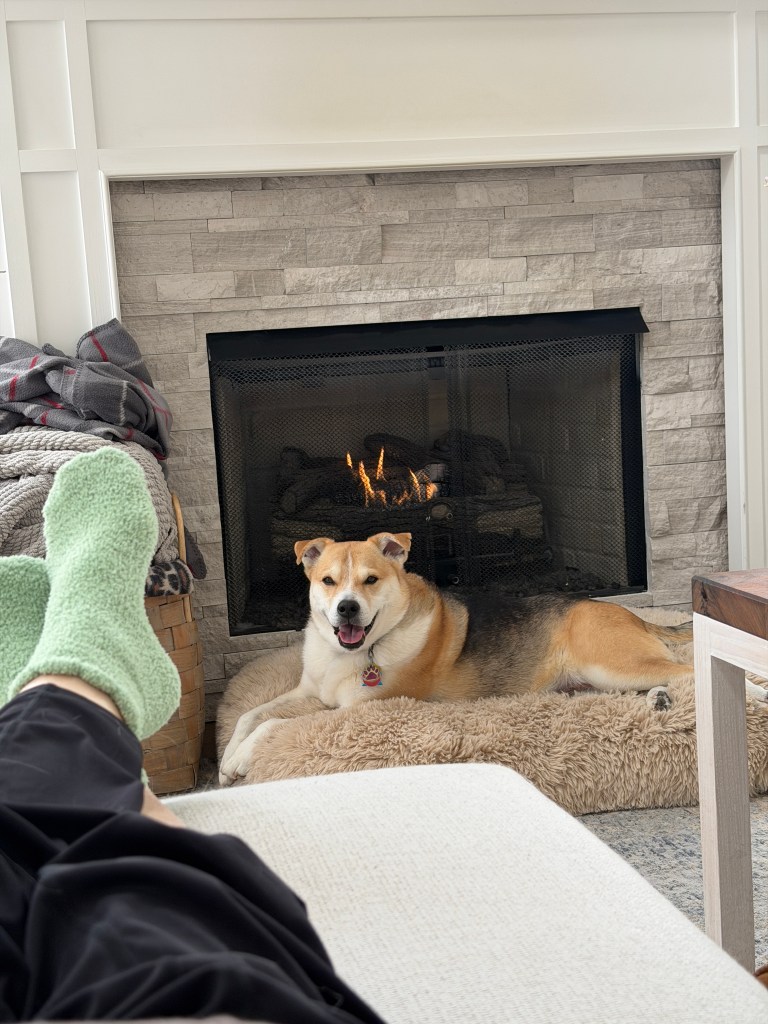 Dr. Wei sits next to the Divinci with the robotic surgical arms over an operating table behind him. 